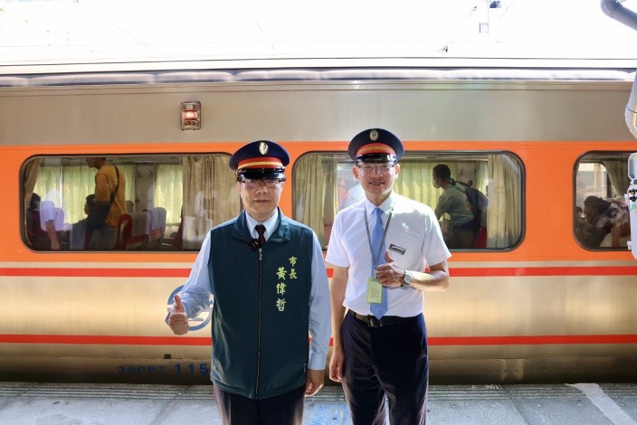 台南市長黃偉哲與台鐵人員在地面列車旁合影