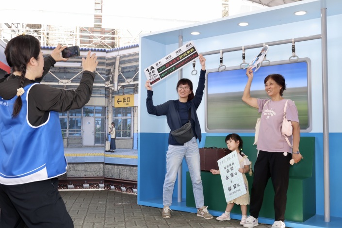 民眾在台南車站鐵道主題看板前拍照